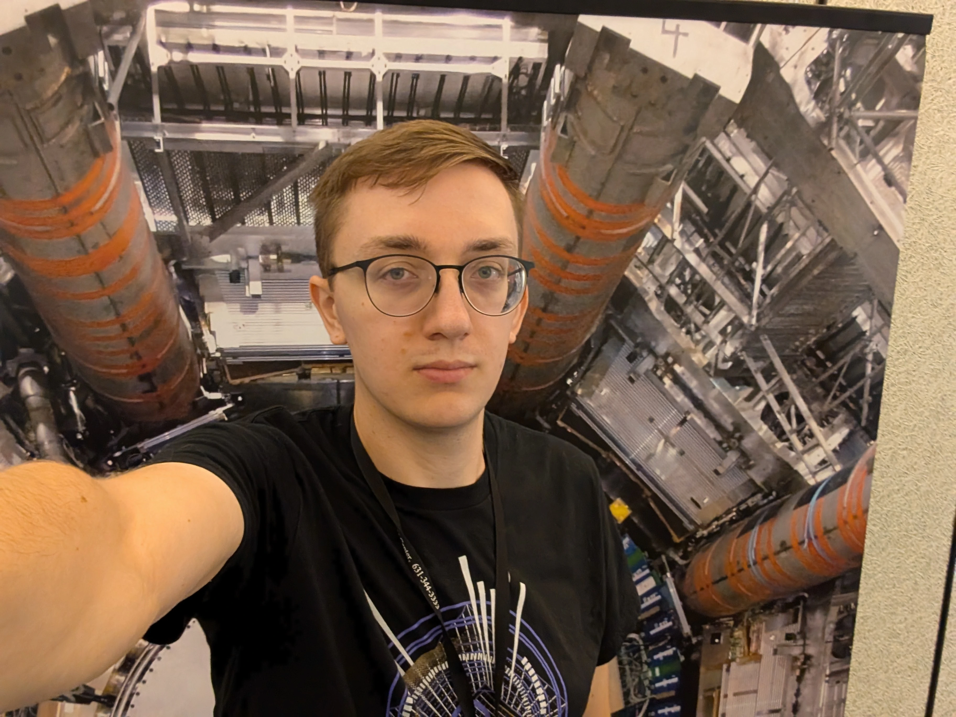 A selfie of me in front of an ATLAS poster